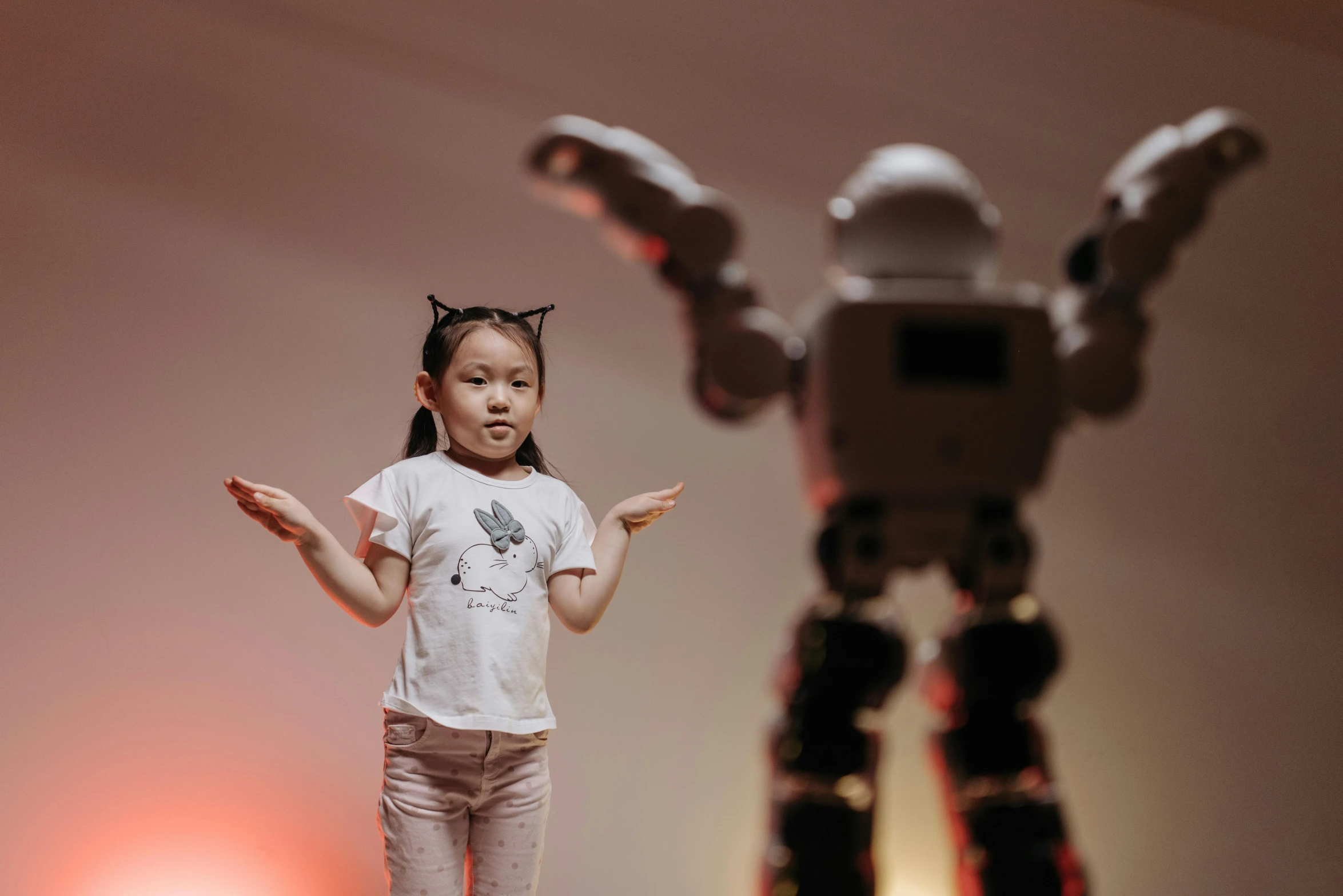 a little girl standing in front of a robot, inspired by Ai-Mitsu, pexels contest winner, interactive art, on his hind legs, short focus, eva elfie, concept photo