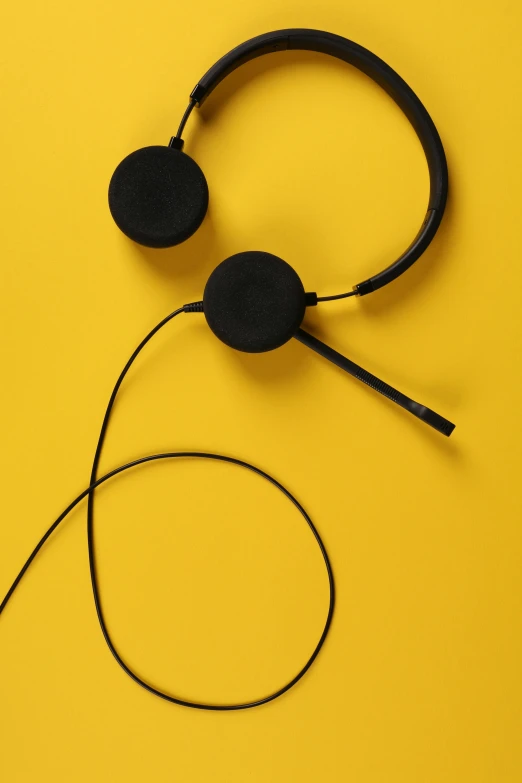 a pair of headphones on a yellow background, by Sven Erixson, trending on pexels, black wired cables, working in a call center, thumbnail, 9