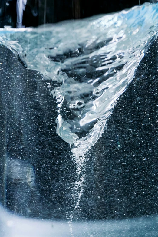 a glass filled with water sitting on top of a counter, inspired by Lucio Fontana, unsplash, lyrical abstraction, frozen waterfall, dynamic closeup, swimming to surface, made of water