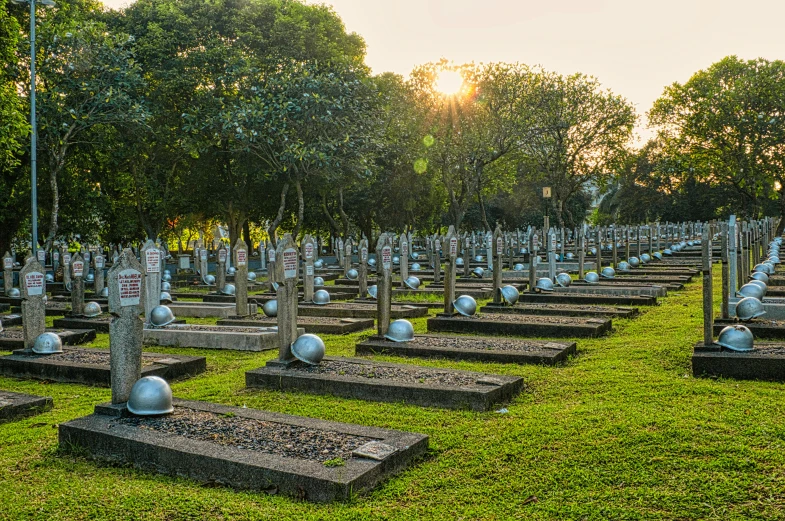 a cemetery filled with lots of tombstones and trees, a photo, by Bernardino Mei, sri lanka, sun down, profile image, war photo