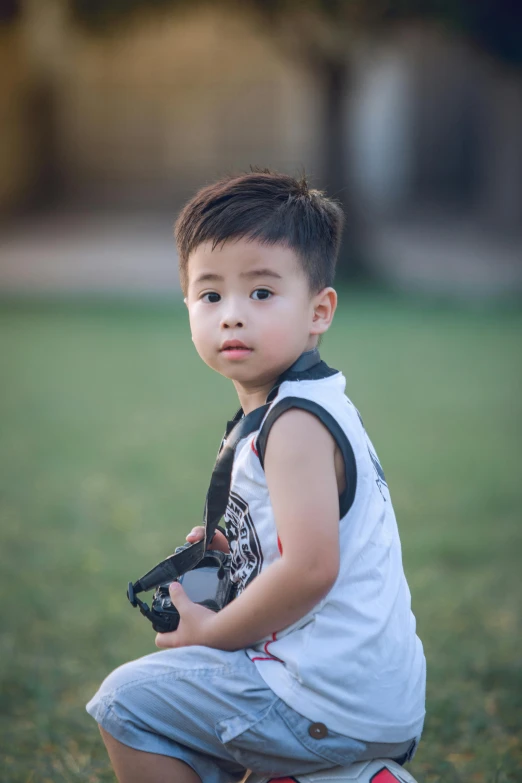 a little boy that is sitting in the grass, a picture, by Reuben Tam, pexels contest winner, realism, young cute wan asian face, ready to model, shot with a camera flash, body and headshot