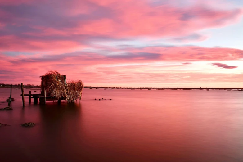 a boat sitting on top of a body of water, by Peter Churcher, unsplash contest winner, australian tonalism, the sky is pink, panoramic photography, marsh, red water