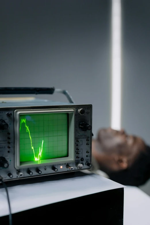 a radio sitting on top of a table next to a person, inspired by Bruce Nauman, unsplash, kinetic art, oscilloscope, in a laboratory, afro tech, photographed for reuters