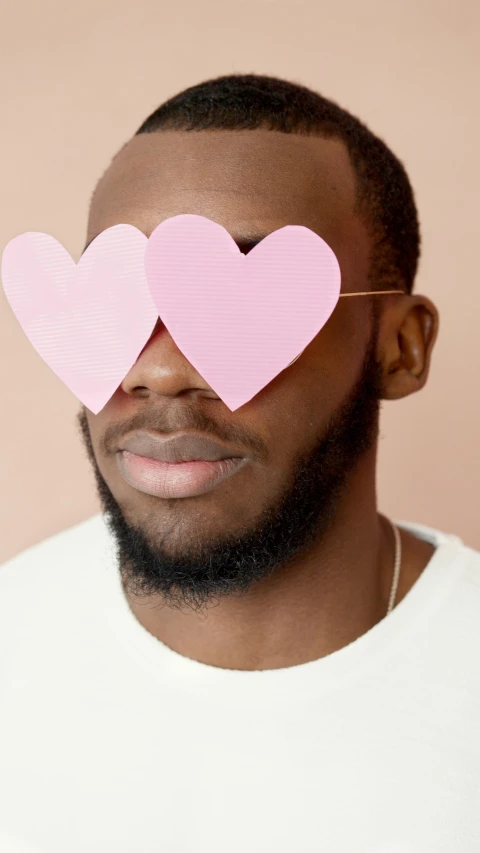 a man with two pink hearts on his face, trending on pexels, black people, nerds, romantic lead, press photo