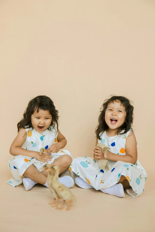 a couple of little girls sitting next to each other, pexels contest winner, minimalism, lighthearted celebration, repeating pattern, cream, full product shot