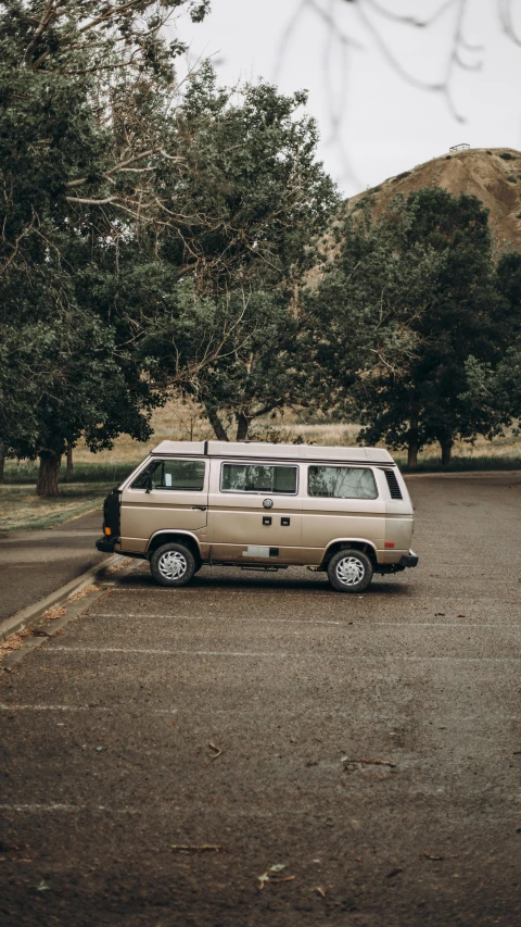 a van parked in a parking lot next to trees, a picture, unsplash contest winner, renaissance, taken in the early 1990s, high quality photo, brown, 🤠 using a 🖥