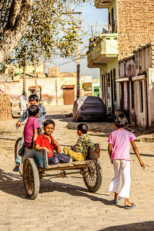 a group of children riding on the back of a horse drawn carriage, a picture, pexels contest winner, happening, in a village, on an indian street, sunny environment, square