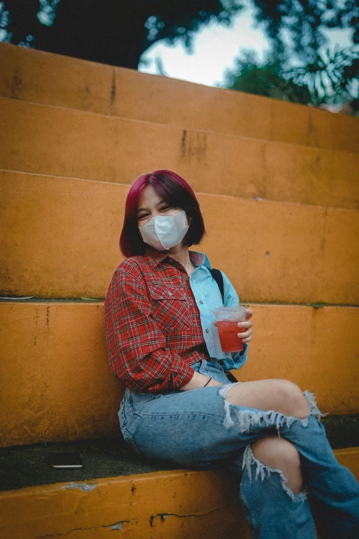 a woman wearing a face mask sitting on a bench, a picture, inspired by Elsa Bleda, trending on pexels, graffiti, red short hair, with a drink, male ulzzang, outfit photo