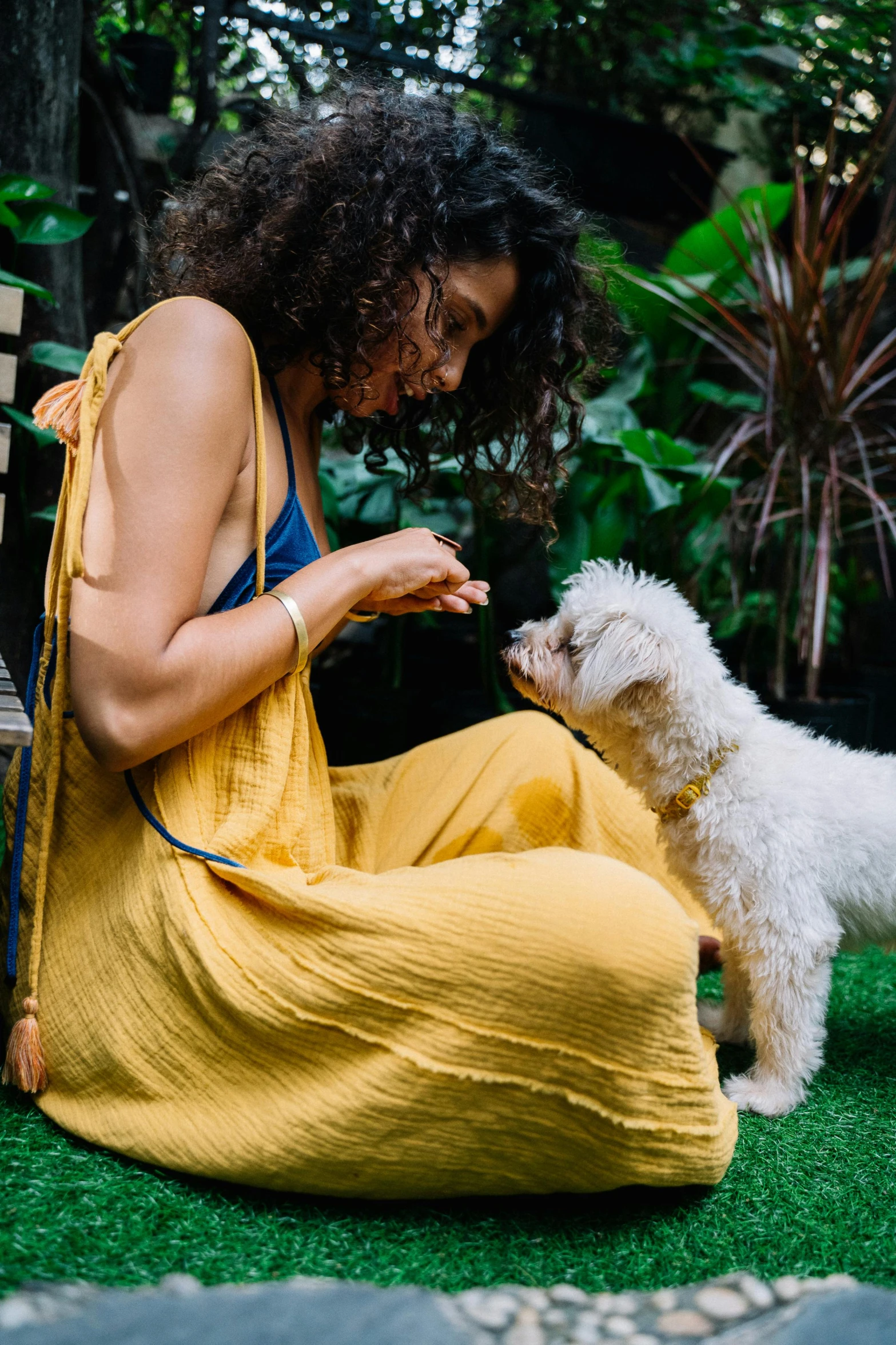 a woman in a yellow dress petting a white dog, pexels contest winner, botanicals, eating outside, anjali mudra, at home