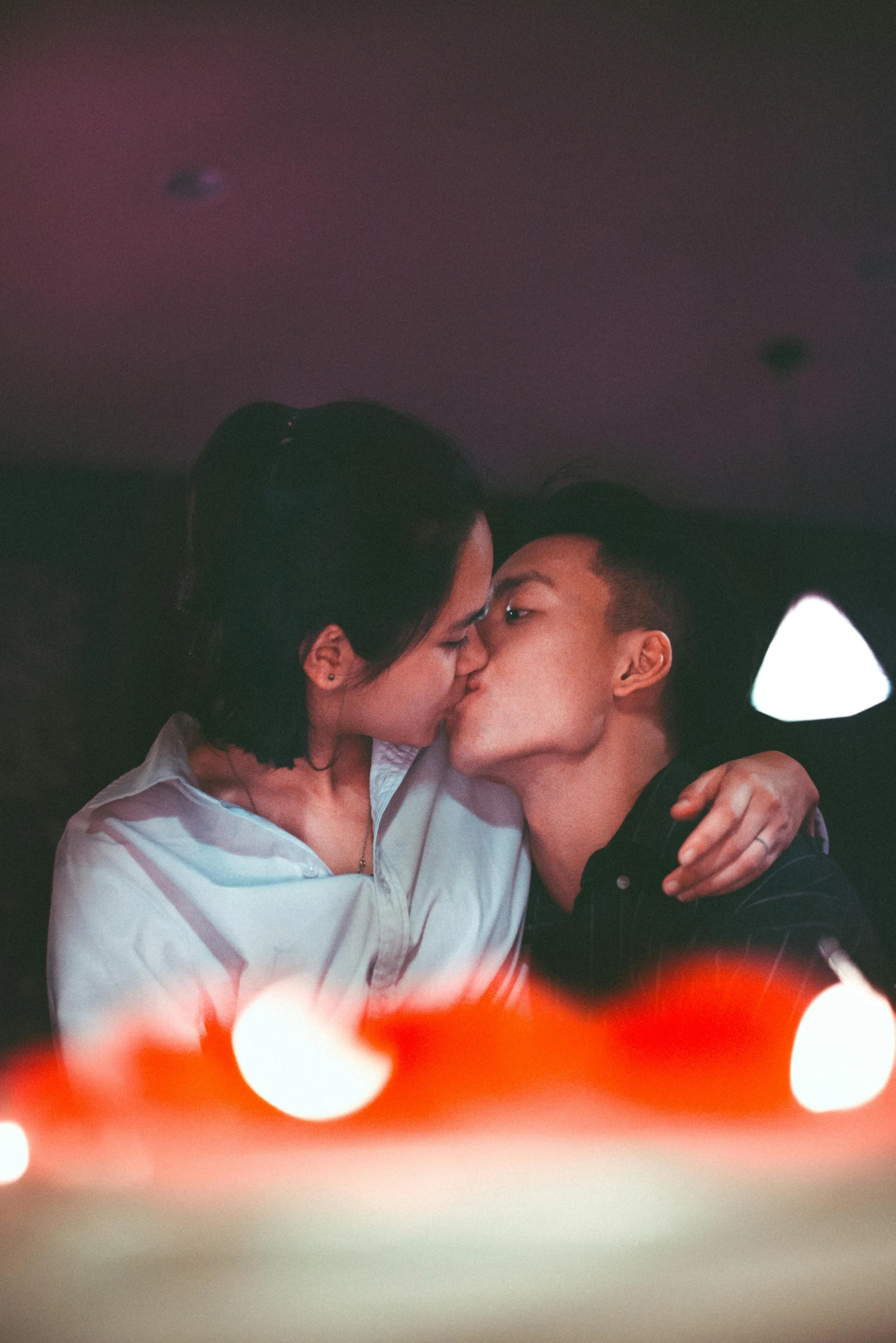 a man and a woman kissing in front of a cake, inspired by Nan Goldin, trending on unsplash, lesbian, asian man, lights, cute boys