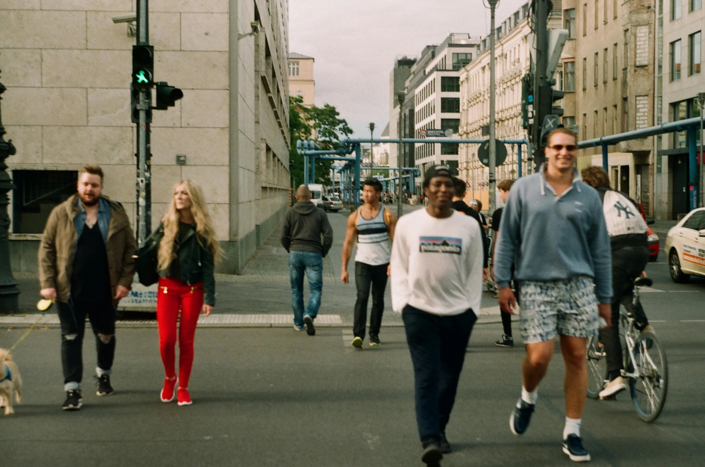 a group of people walking across a street, inspired by Thomas Struth, pexels contest winner, hyperrealism, a blond, munich, still from a music video, mix of ethnicities and genders