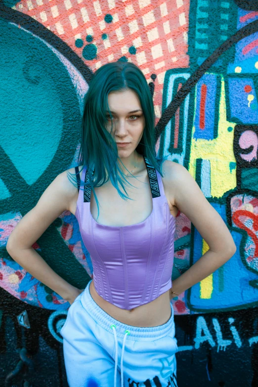 a woman standing in front of a graffiti wall, an album cover, inspired by Elsa Bleda, featured on reddit, violet tight tanktop, sky blue straight hair, ( ( cyberpunk ) ), ((purple))