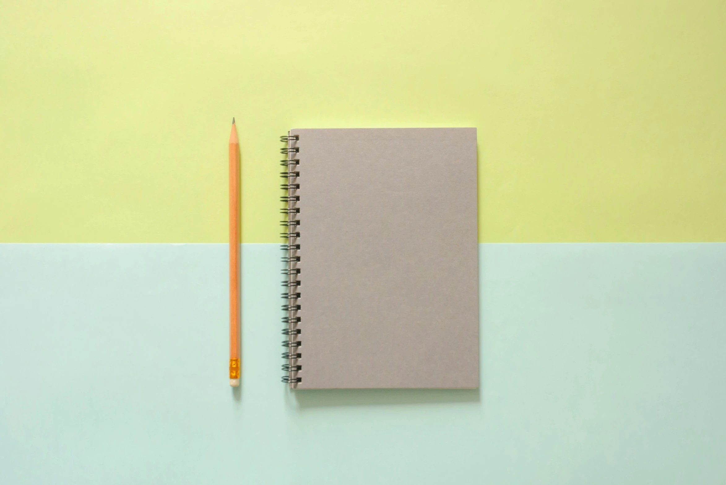 an open notebook with a pencil next to it, by Jan Rustem, pexels, minimalism, pale green background, two tone, silver and yellow color scheme, 15081959 21121991 01012000 4k