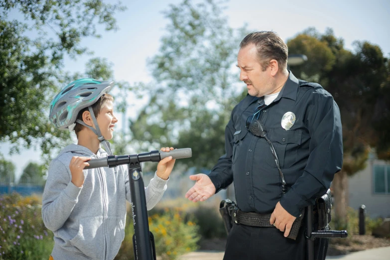 a police officer talking to a woman on a scooter, a portrait, unsplash, happening, teenage boy, california;, schools, actor