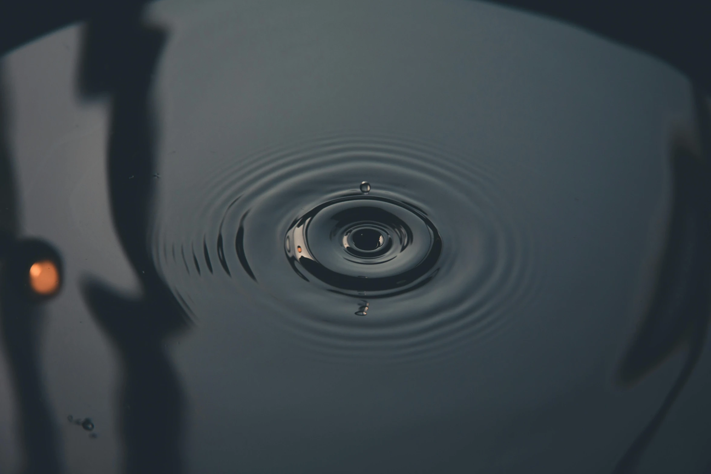 a water drop in the middle of a body of water, inspired by Lucio Fontana, trending on unsplash, whirlpool, deep black, ripple, instagram post