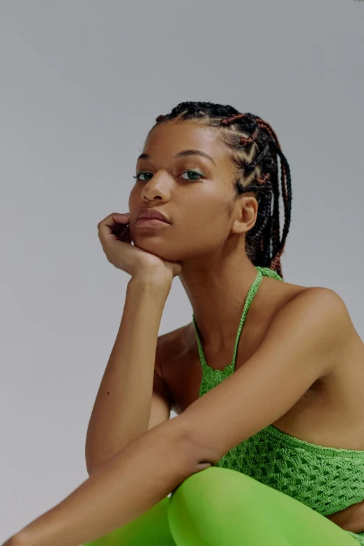 a woman in a green top and green leggings, inspired by Sophia Beale, trending on pexels, renaissance, cornrows braids, i-d magazine, wearing a camisole, head and shoulders view