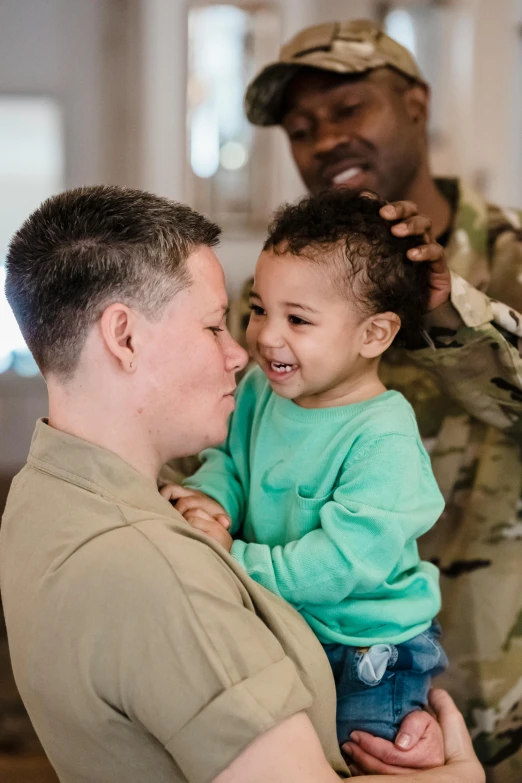 a soldier holds a small child in his arms, trending on unsplash, two men hugging, lesbian, a radiant, mouth agape