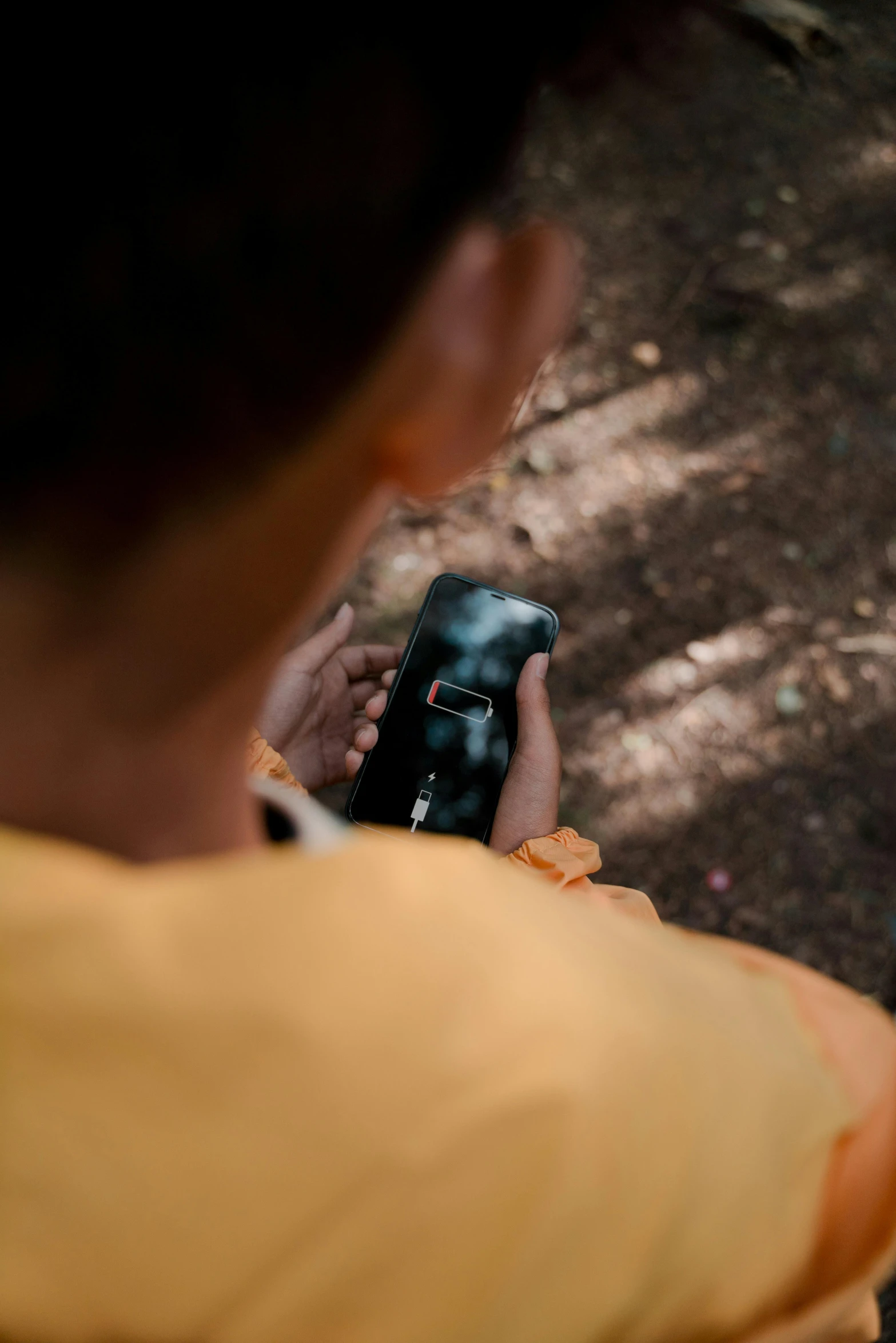 a close up of a person holding a cell phone, a picture, happening, photograph captured in a forest, an orange, dark and dusty, low fi