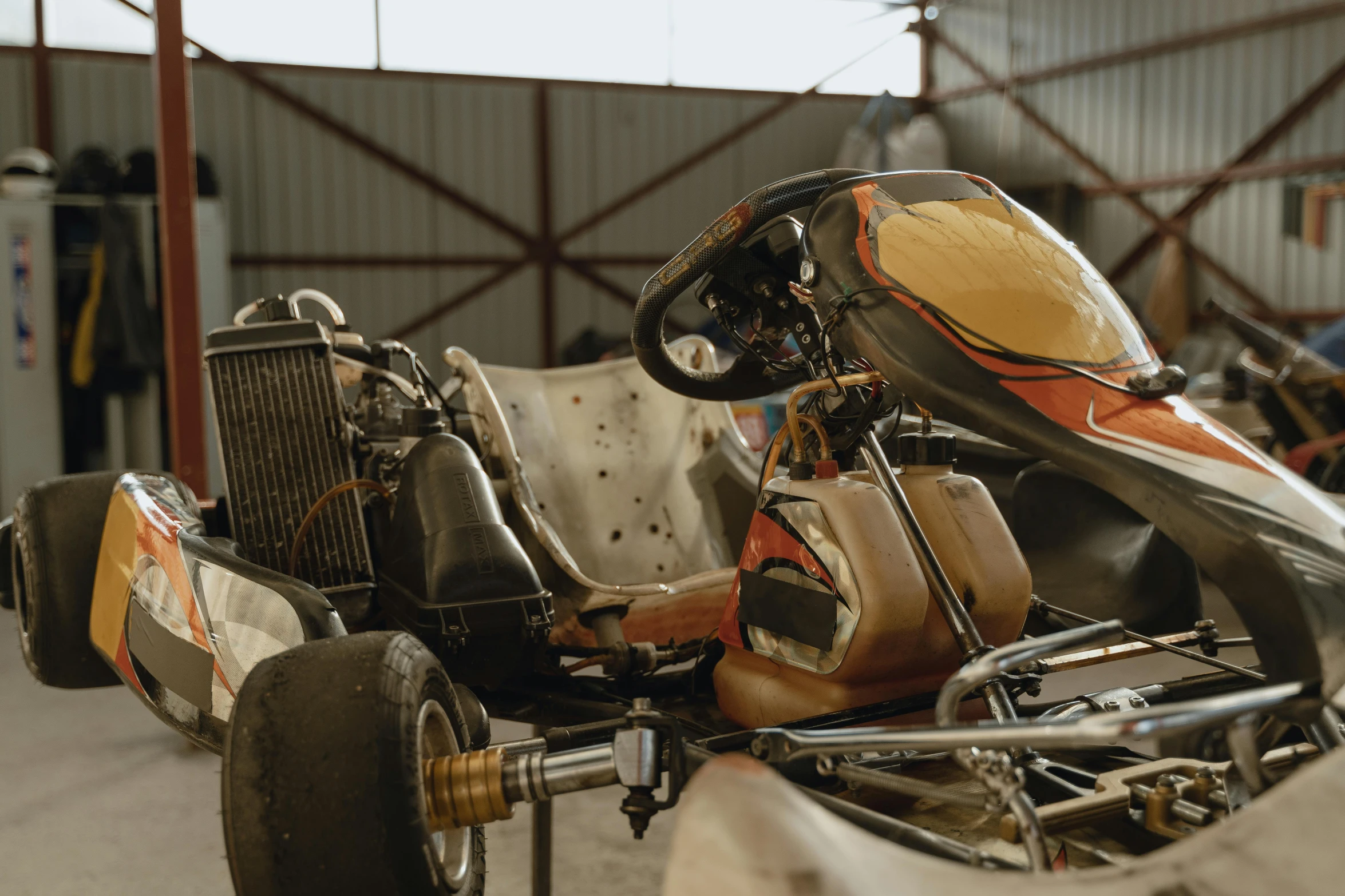 a close up of a race car in a garage, by Daniel Lieske, with vestiges of rusty machinery, lachlan bailey, 8 k wide shot, buggy