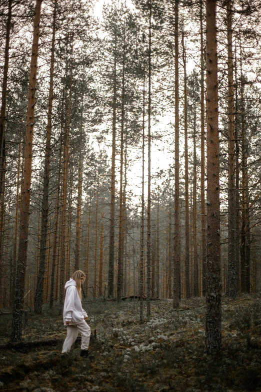 a woman standing in the middle of a forest, by Grytė Pintukaitė, unsplash, multiple stories, russia, holiday, white wood