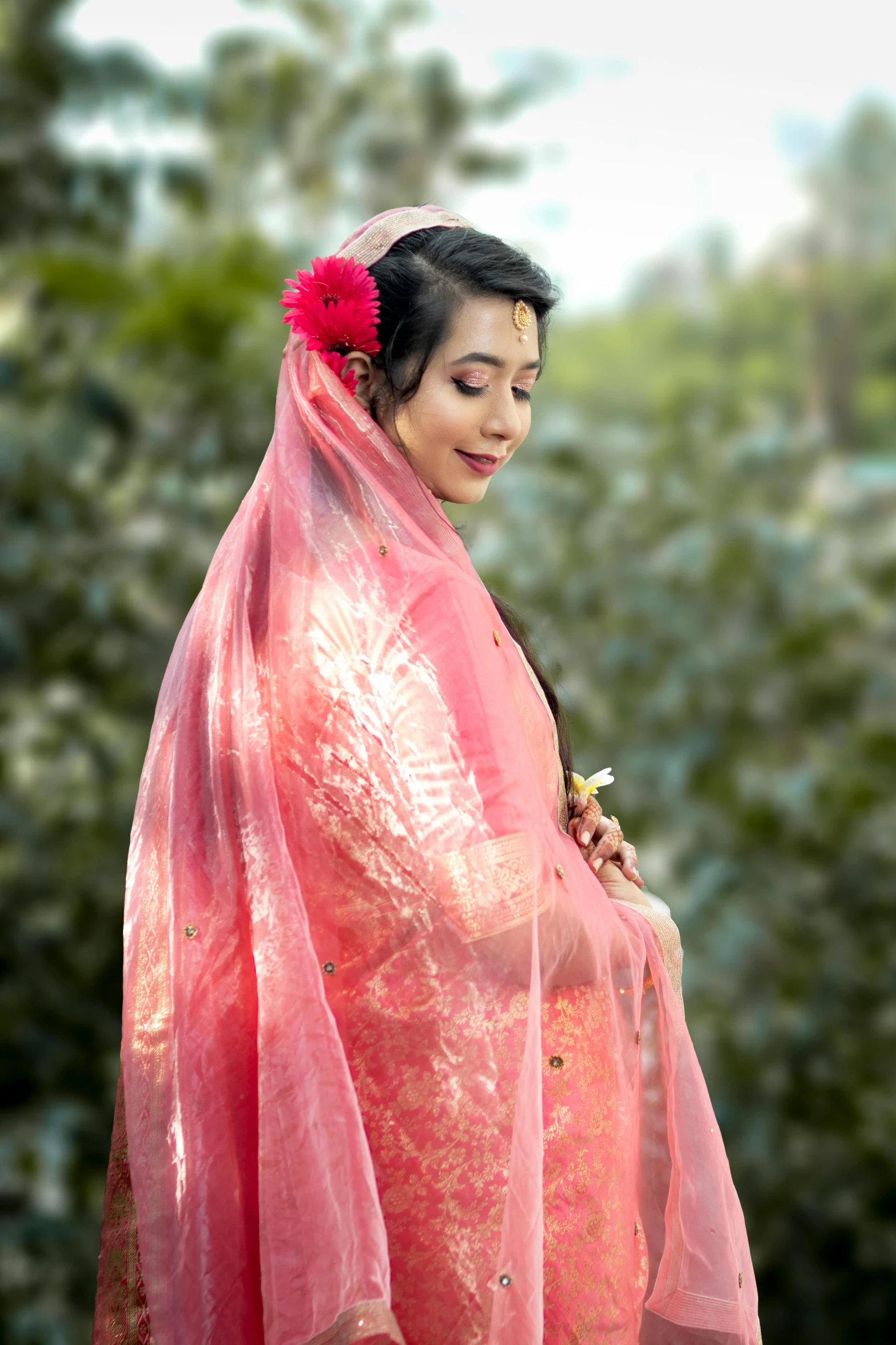 a woman in a pink dress with a flower in her hair, by Sunil Das, shutterstock contest winner, wearing translucent sheet, dressed in a beautiful red cloak, assamese aesthetic, made of silk paper