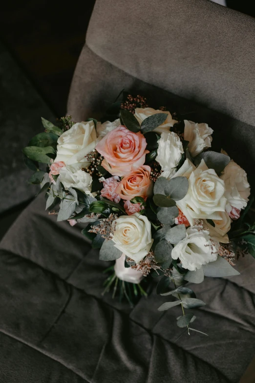 a bouquet of flowers sitting on top of a chair, laying down, laying on roses, in muted colours, full of details