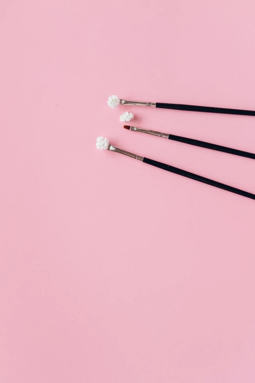 a set of chopsticks on a pink background, by Elsa Bleda, unsplash, hair are wired cables, real pearls, medium: black pencil, marshmallow