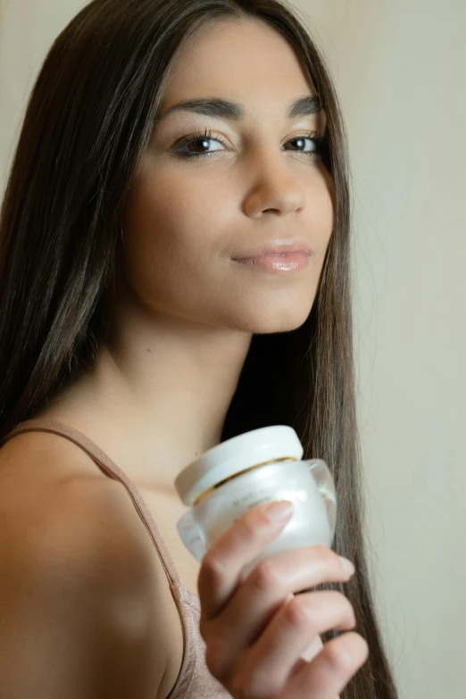 a beautiful young woman holding a cup of coffee, a portrait, by Julian Allen, cosmetics, jars, hispanic, foam