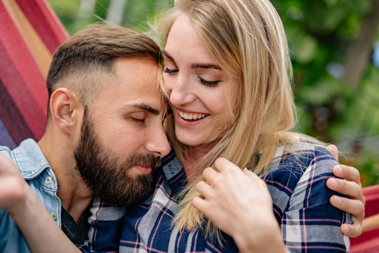 a man and a woman sitting in a hammock, pexels contest winner, very attractive man with beard, wearing a flannel shirt, upclose, woman holding another woman