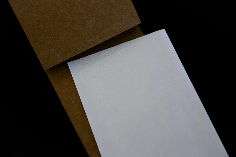 a couple of pieces of paper sitting on top of each other, dark sienna and white, clear detailed view, medium angle, thumbnail