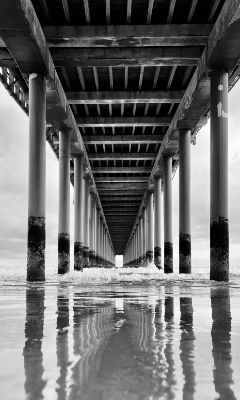 a black and white photo of the underside of a pier, by Dave Melvin, unsplash contest winner, renaissance, concrete pillars, gopro photo, in oil”, long view