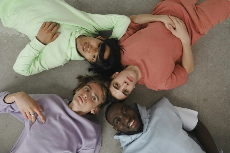 a group of people laying on top of each other, by Matija Jama, trending on pexels, renaissance, pastel clothing, issey miyake, complementary colours, wearing shirts