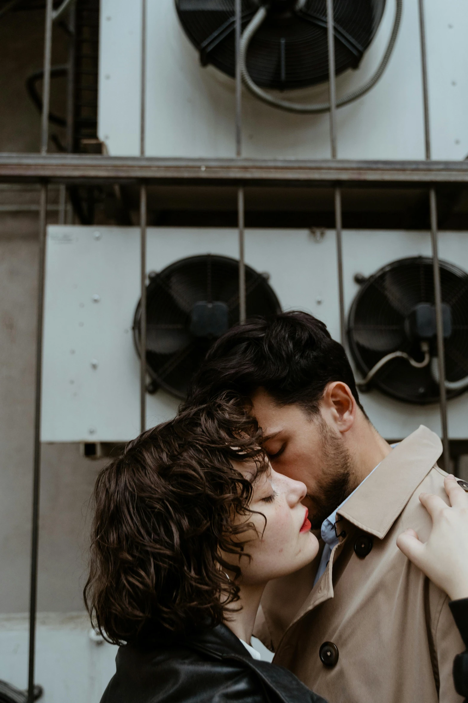 a man and woman standing next to each other in front of a building, inspired by Elsa Bleda, pexels contest winner, curly bangs, loving embrace, ignant, brown haired