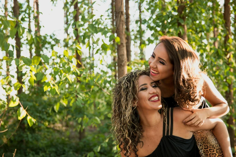 a couple of women standing next to each other, pexels, romanticism, in front of a forest background, avatar image, latinas, pure joy