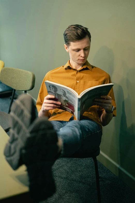 a man sitting in a chair reading a book, pexels contest winner, hyperrealism, dressed casually, thin young male, on a yellow canva, thumbnail