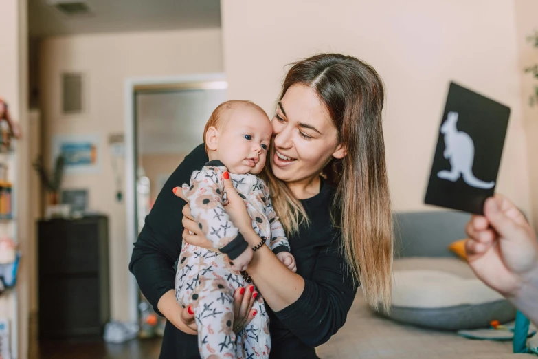 a woman holding a baby in her arms, pexels contest winner, antipodeans, avatar image, pokimane, high quality image