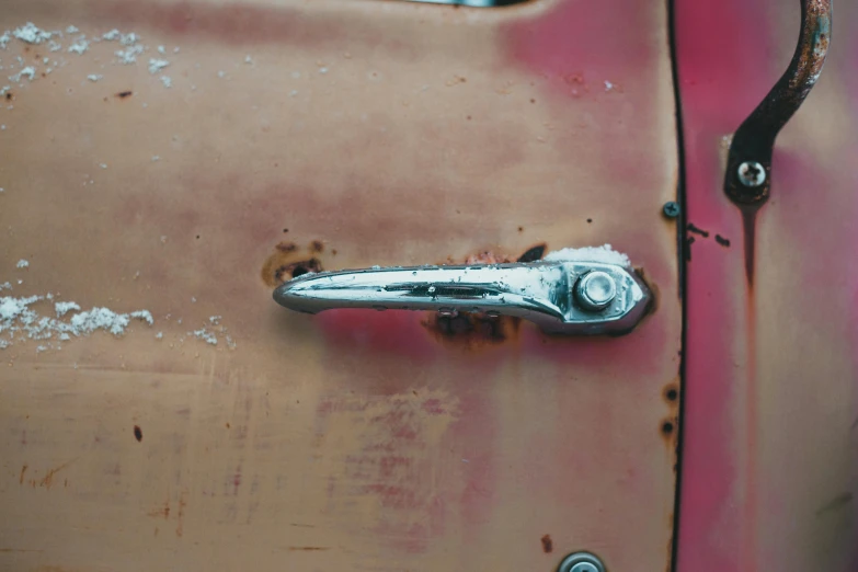 a close up of a rusted car door handle, an album cover, by Filip Hodas, unsplash, pink, chrome red, made of metal, tail fin