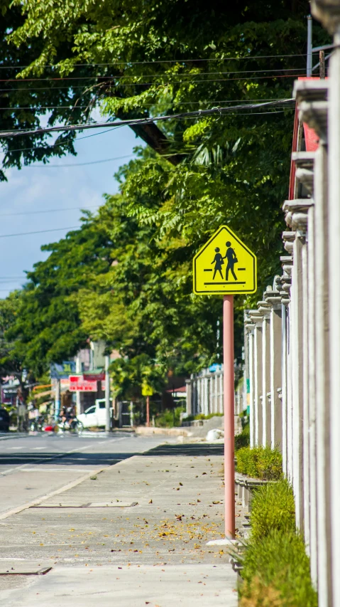 a yellow street sign sitting on the side of a road, by Sven Erixson, pexels, philippines, square, schools, high quality photo