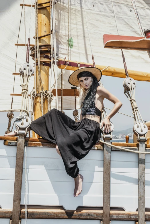 a woman in a hat is sitting on a boat, pexels contest winner, renaissance, wide leg hakama trousers, on a pirate ship, wearing a cropped black tank top, promotional image