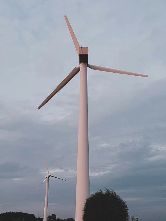 a group of wind turbines sitting on top of a lush green field, a colorized photo, unsplash contest winner, pink, two giant towers, profile image, no cropping