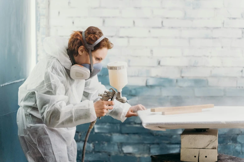 a woman using a spray gun to paint a piece of wood, an airbrush painting, pexels contest winner, wearing lab coat and a blouse, avatar image, french provincial furniture, construction