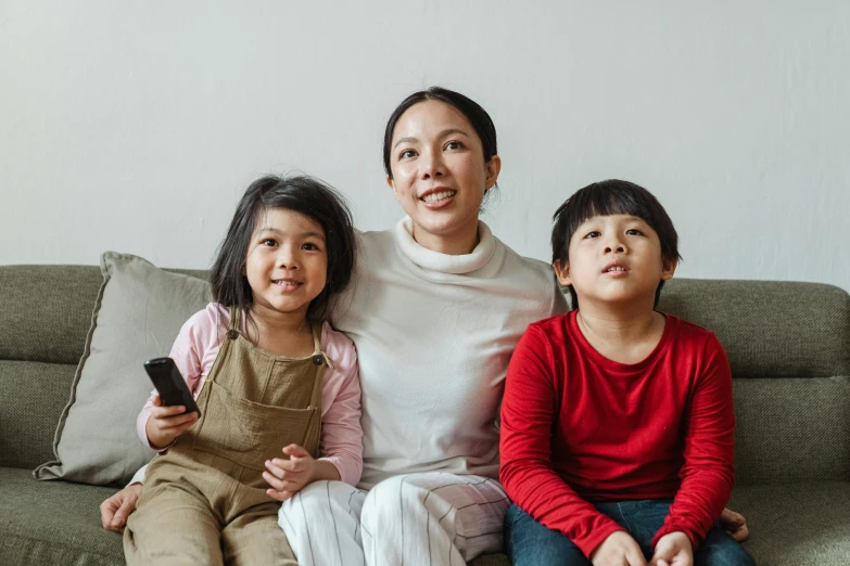 a woman and two children sitting on a couch, a cartoon, pexels, an asian woman, everything fits on the screen, korean woman, multiple stories