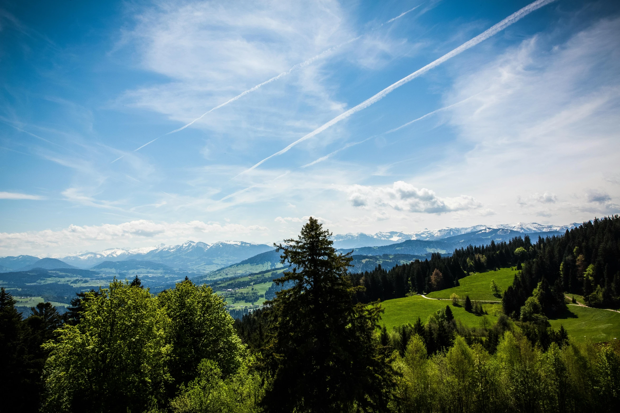 a view of the mountains from the top of a hill, by Matthias Weischer, pexels contest winner, les nabis, overlooking a valley with trees, clear blue skies, a green, photo of zurich