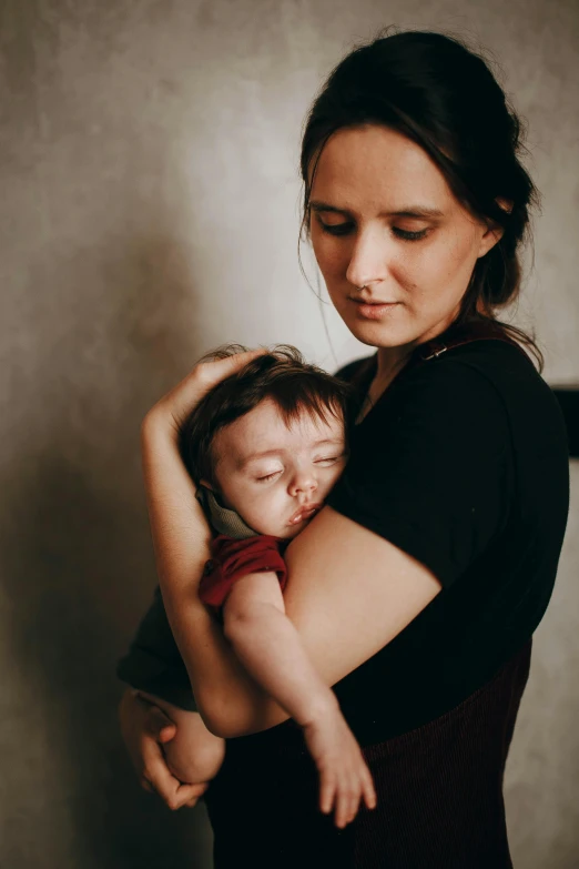 a woman holding a baby in her arms, a picture, by Lucia Peka, pexels contest winner, sleepy, plain background, portrait of sanna marin, 15081959 21121991 01012000 4k