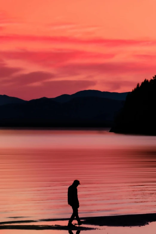 a person walking on a beach at sunset, by Doug Ohlson, pexels contest winner, romanticism, british columbia, sittin, lake, red water
