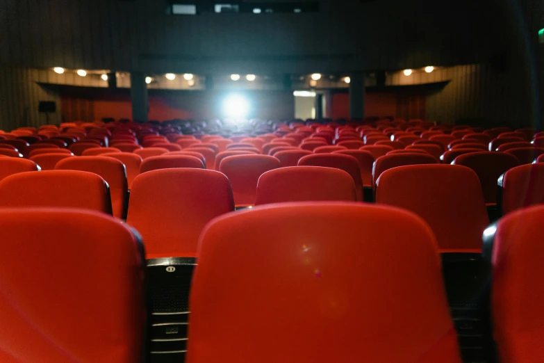 a room filled with lots of red chairs, pexels, happening, movie lights, looking across the shoulder, no - text no - logo, instagram post