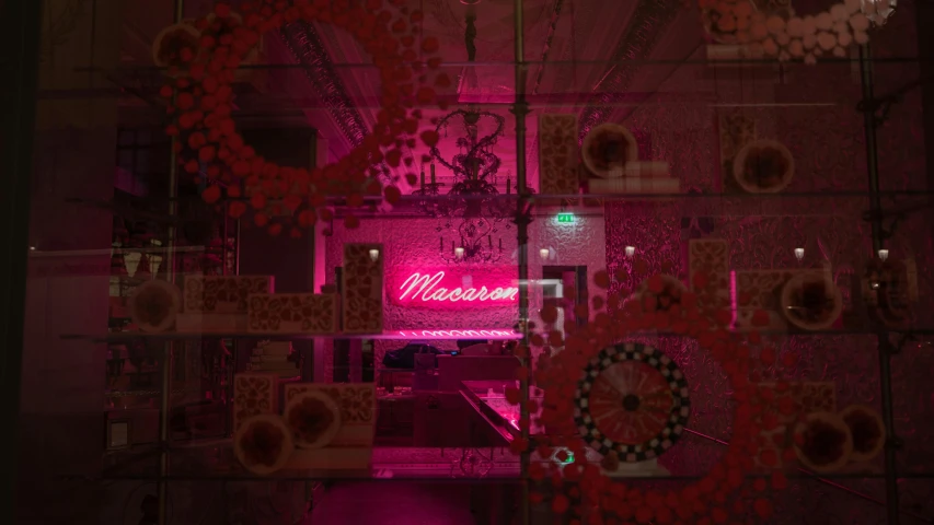 a pink neon sign sitting in the middle of a room, by Alice Mason, maximalism, covered with pink marzipan, manuka, set at night, crimson themed