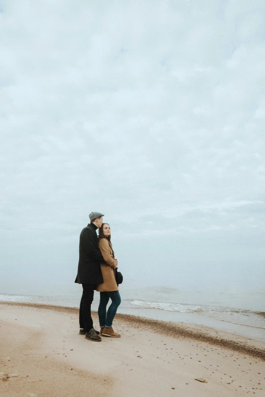 a man and woman standing on a beach next to the ocean, fall season, tall thin, 15081959 21121991 01012000 4k, alexey gurylev