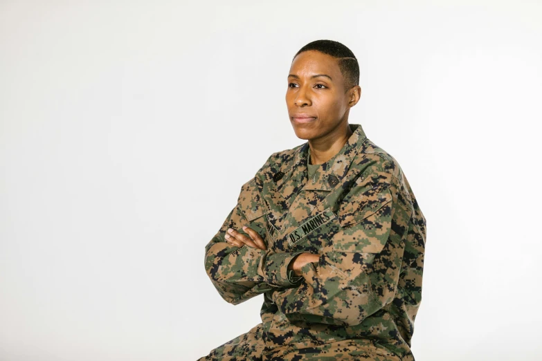 a woman in a military uniform posing for a picture, a portrait, by Ellen Gallagher, pexels, from kehinde wiley, non binary model, sitting down, marine