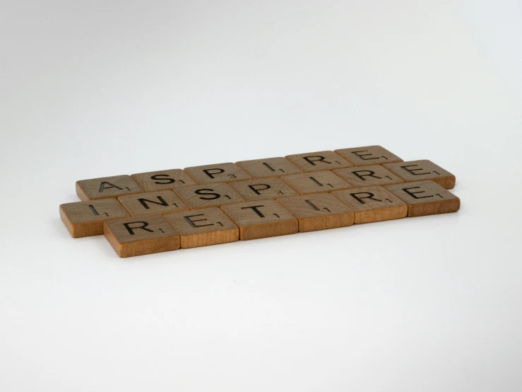 a scrabble board with the word inspire written on it, inspired by Ian Hamilton Finlay, temporary art, asset on grey background, wooden banks, brown, brick